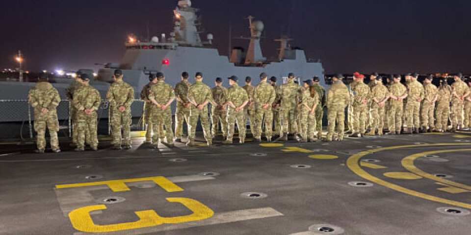 Den nye besætning på helikopterdækket af Esbern Snare, med fregatten Absalon i baggrunden lægger fra kaj på den spanske flådestation i Rota. Foto: Forsvaret