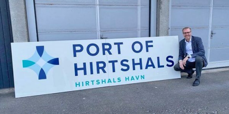 Per Holm Nørgaard ved siden af Hirtshals Havns nye logo. Foto: Hirtshals Havn