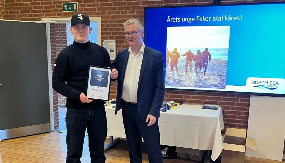 Fiskeriminister Jacob Jensen kårer Philip Bach Jensen som 'Årets Unge Fisker'.